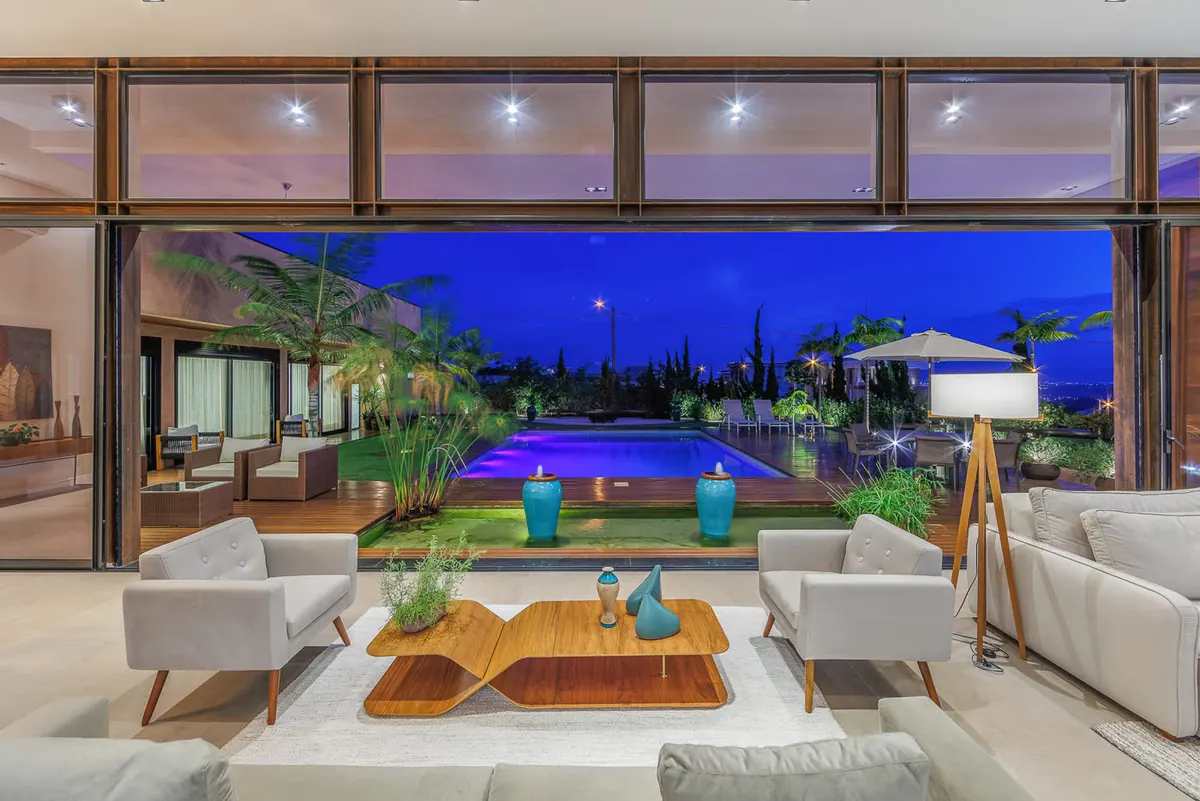 Sala de estar ao entardecer com vista para a piscina